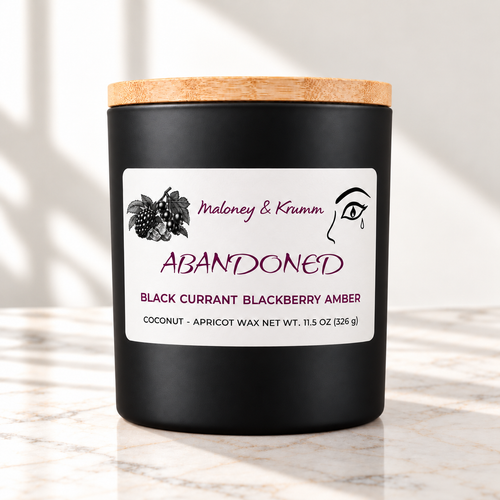 Abandoned candle in matte black jar on ivory marble with white background