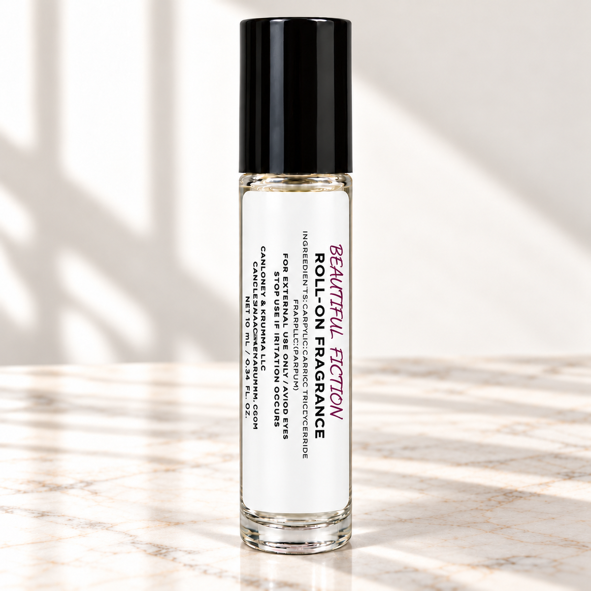 Beautiful Fiction 10 mL roll-on fragrance with full warning label on ivory marble and white background