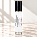 Gravel Road 10 mL roll-on fragrance with full warning label on ivory marble and white background