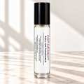 Past Midnight 10 mL roll-on fragrance with full warning label on ivory marble and white background