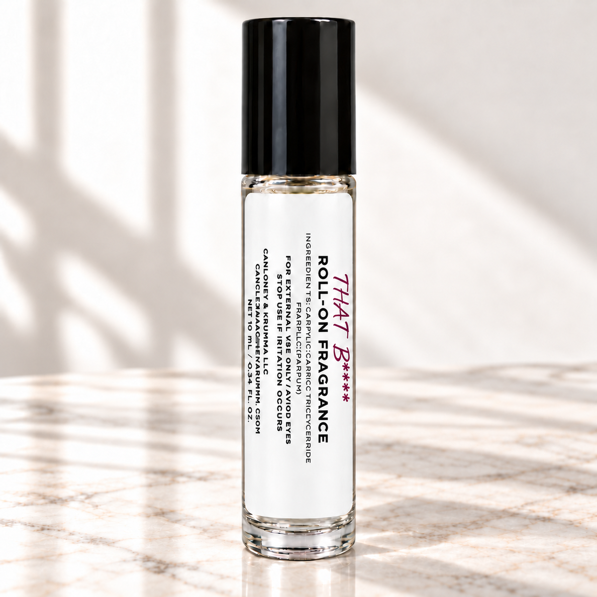 That Bitch 10 mL roll-on fragrance on ivory marble