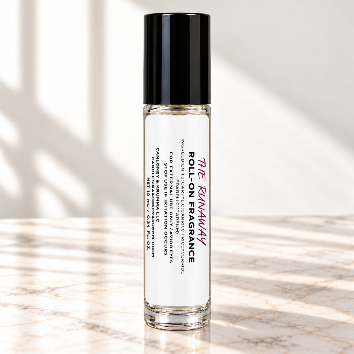 The Runaway 10 mL roll-on fragrance with full warning label on ivory marble and white background